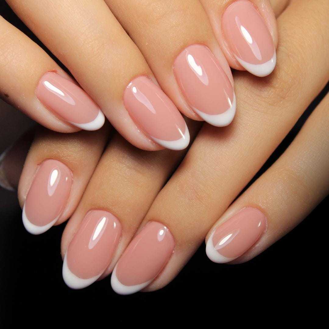 French manicured hands showcasing elegant pink and white nail tips.